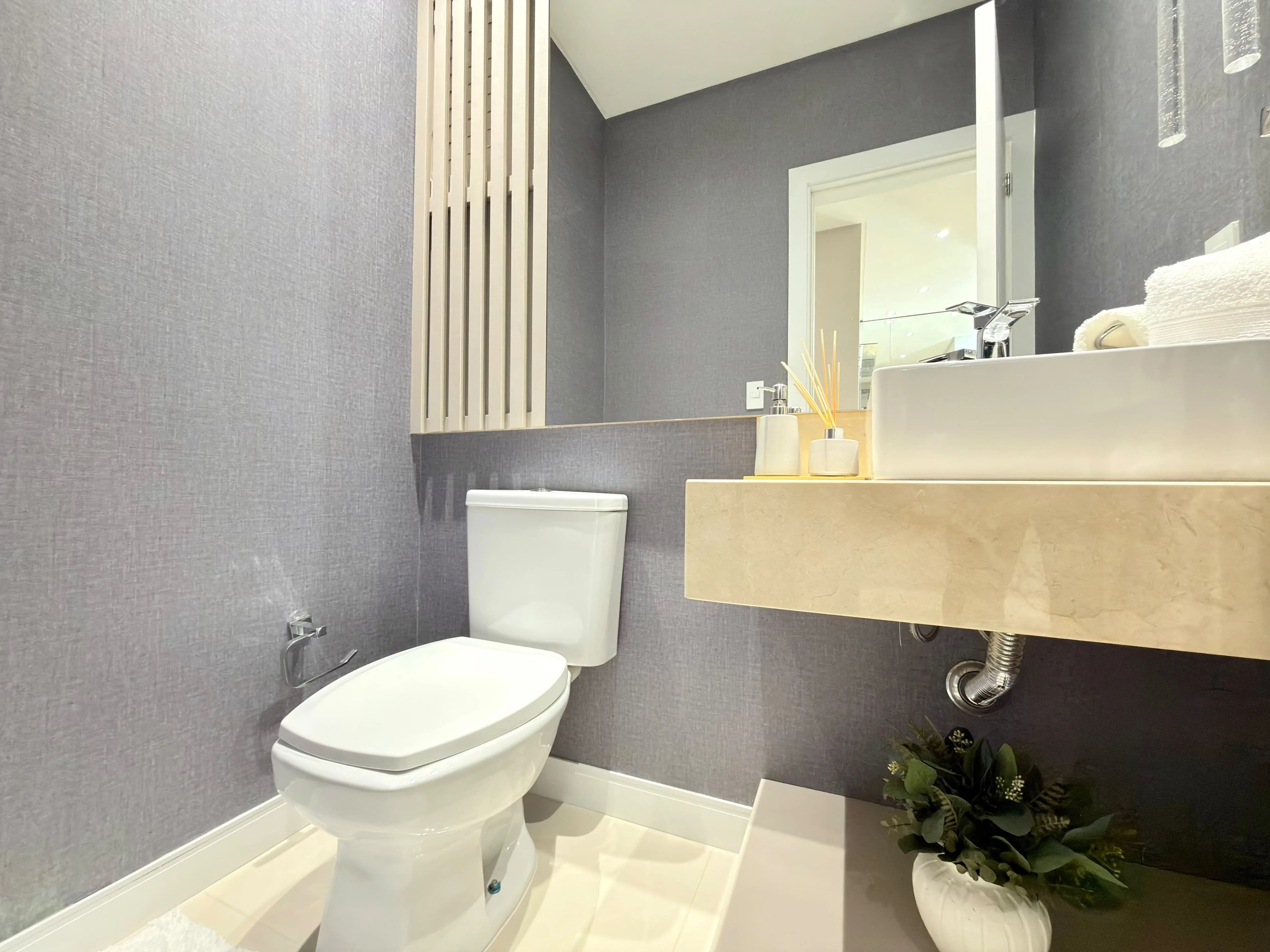 Banheiro com box de vidro e acabamento em porcelanato