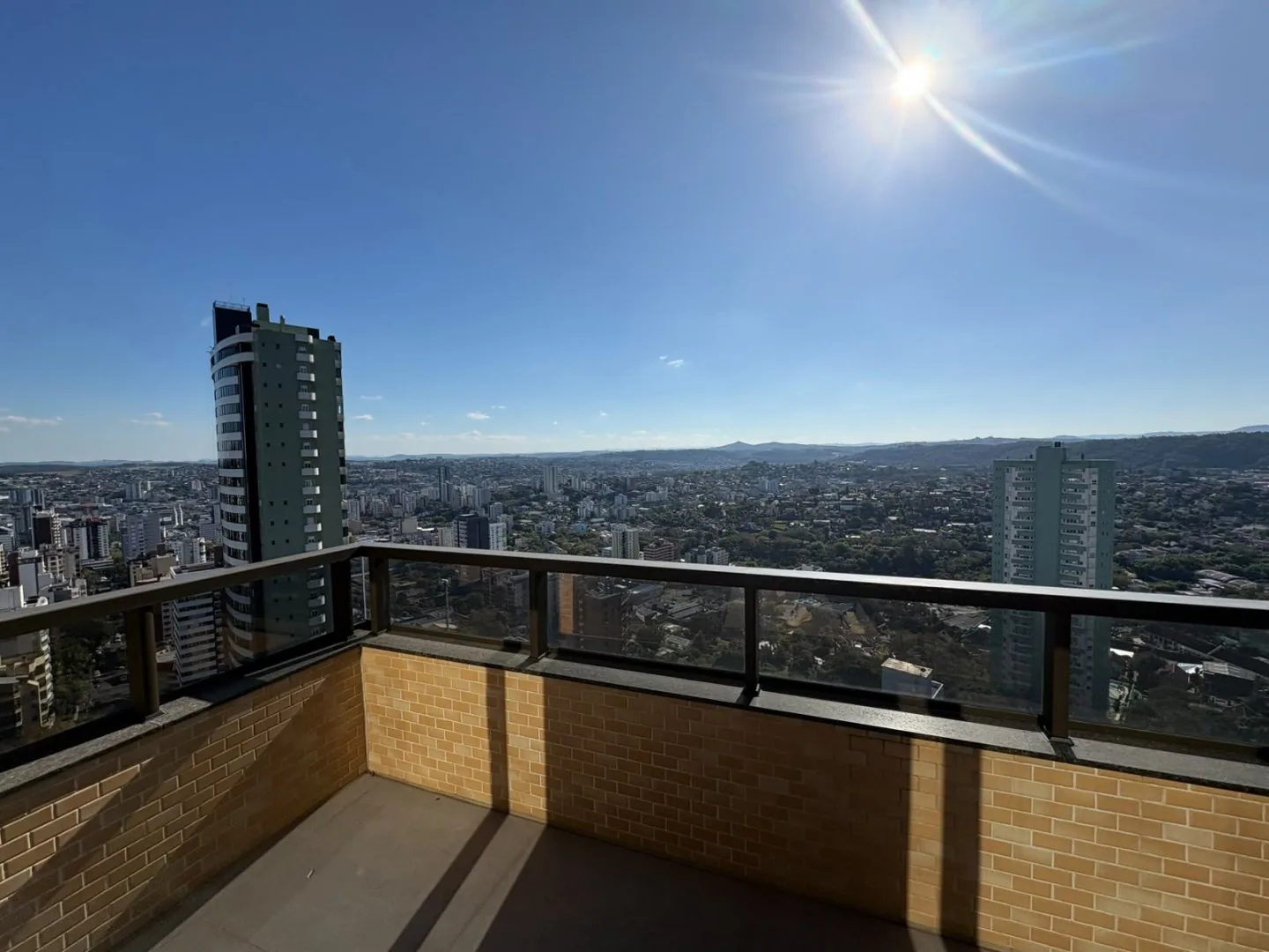 Sacada de esquina com vista para os prédios vizinhos e o horizonte.
