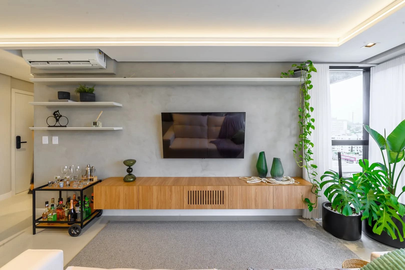 Estar com painel de TV e rack suspenso.
