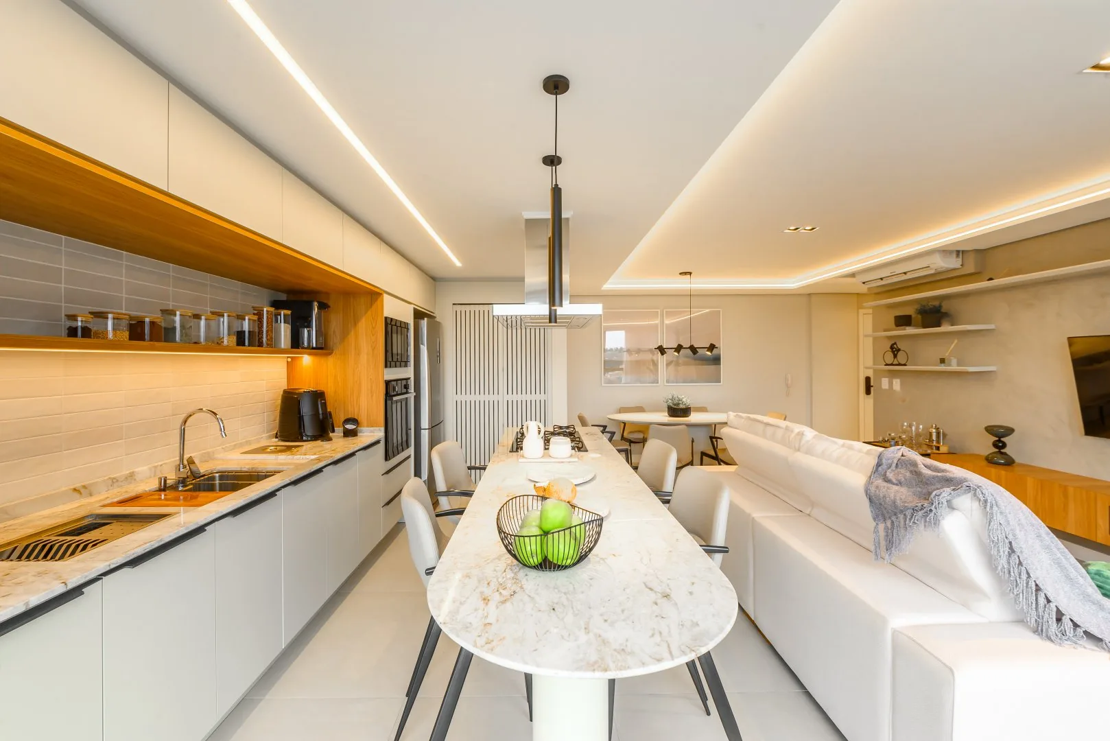 Cozinha com ilha e banquetas.