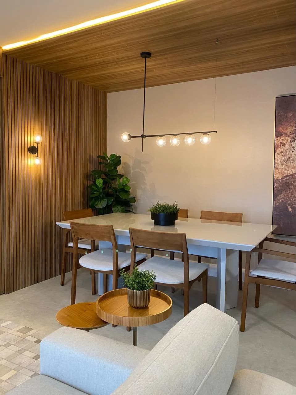 Sala de jantar com mesa de madeira para seis.