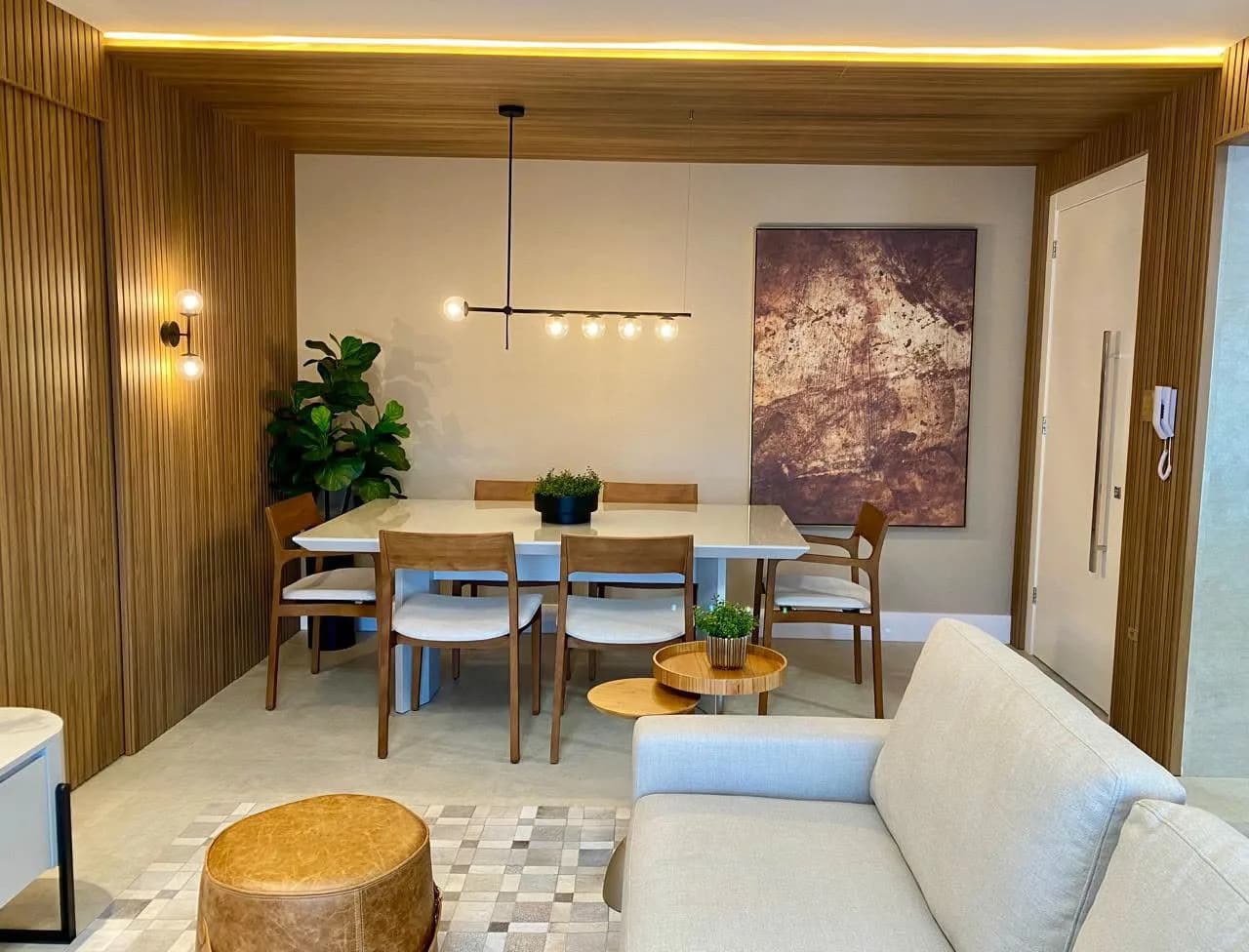 Jantar e estar integrados, com painel de madeira.