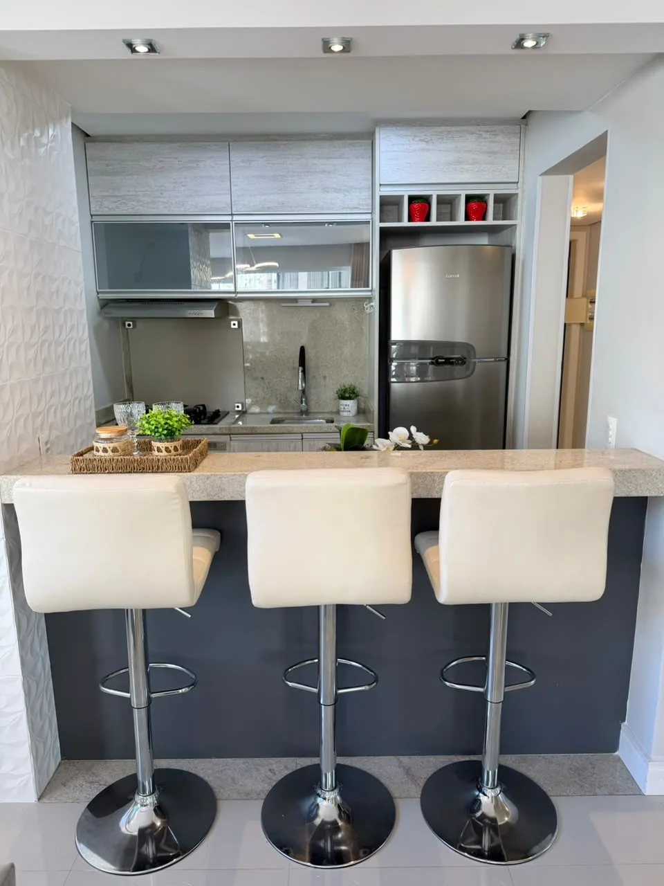 Cozinha americana com bancada e banquetas