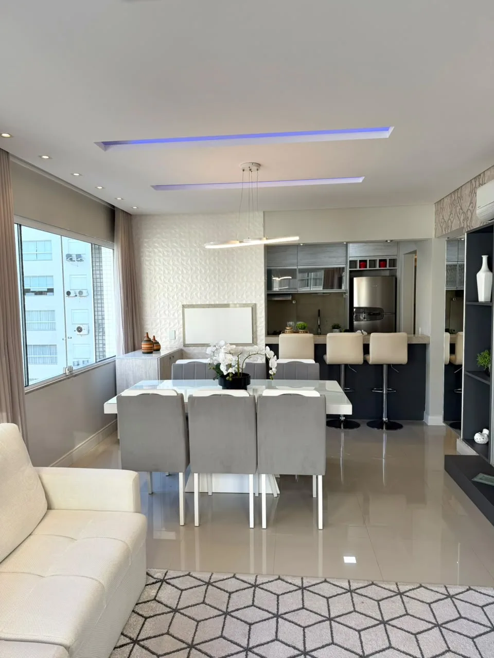 Sala de estar e jantar integradas com sofás brancos