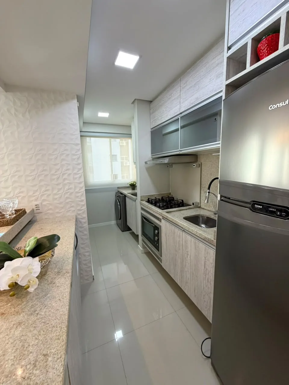 Cozinha planejada com geladeira inox e bancada