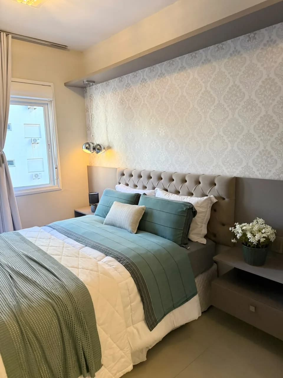 Dormitório com cama de casal e cabeceira estofada