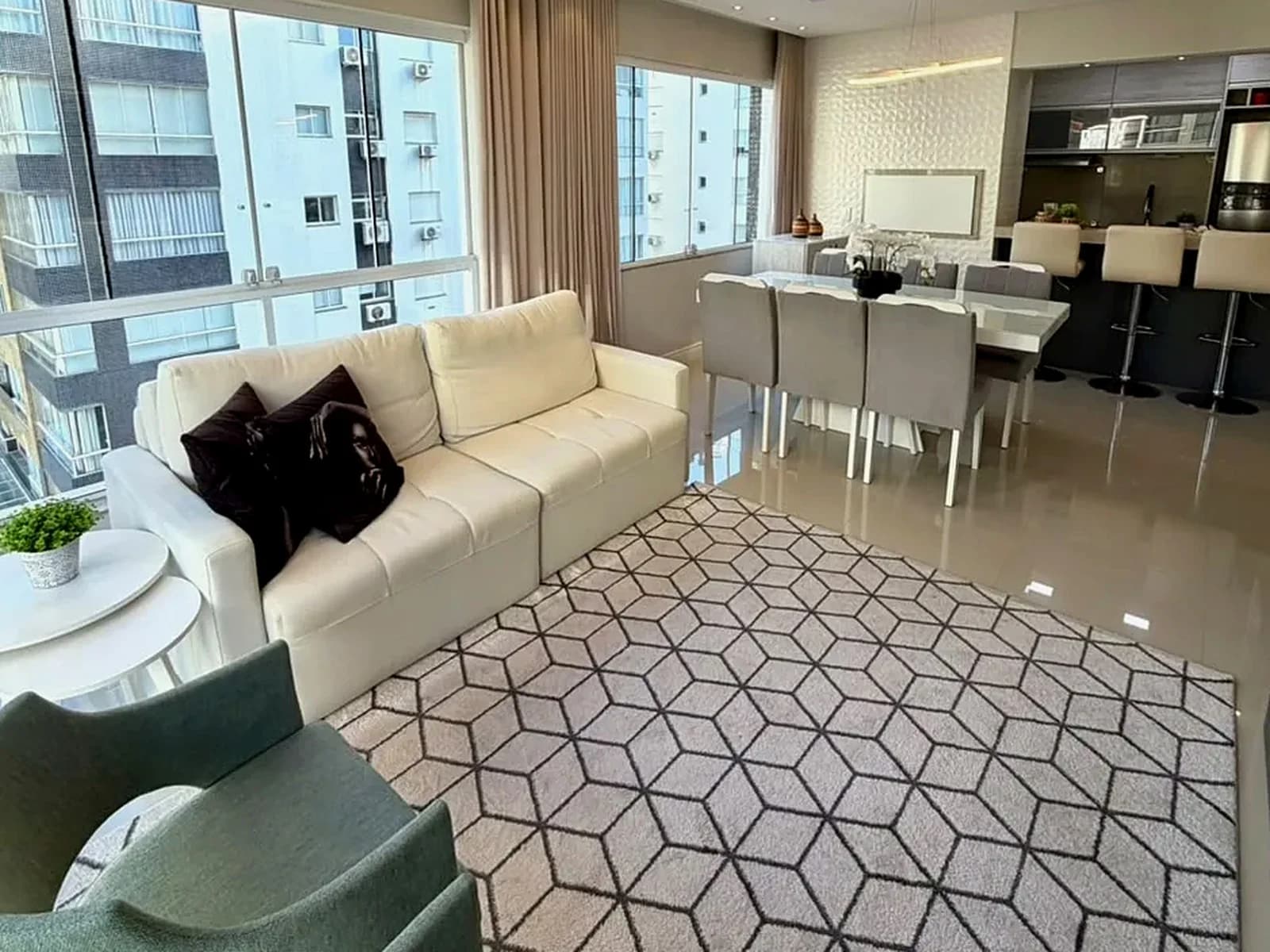 Sala de estar e jantar do Apartamento Tiaraju, com vista para os prédios da região.