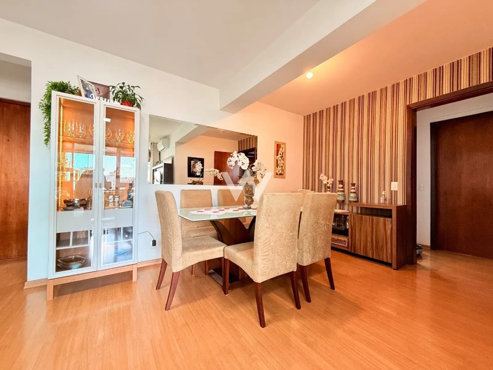 Sala de jantar do apartamento na Rua Vicente da Fontoura, Centro de Novo Hamburgo, com cristaleira e papel de parede listrado.