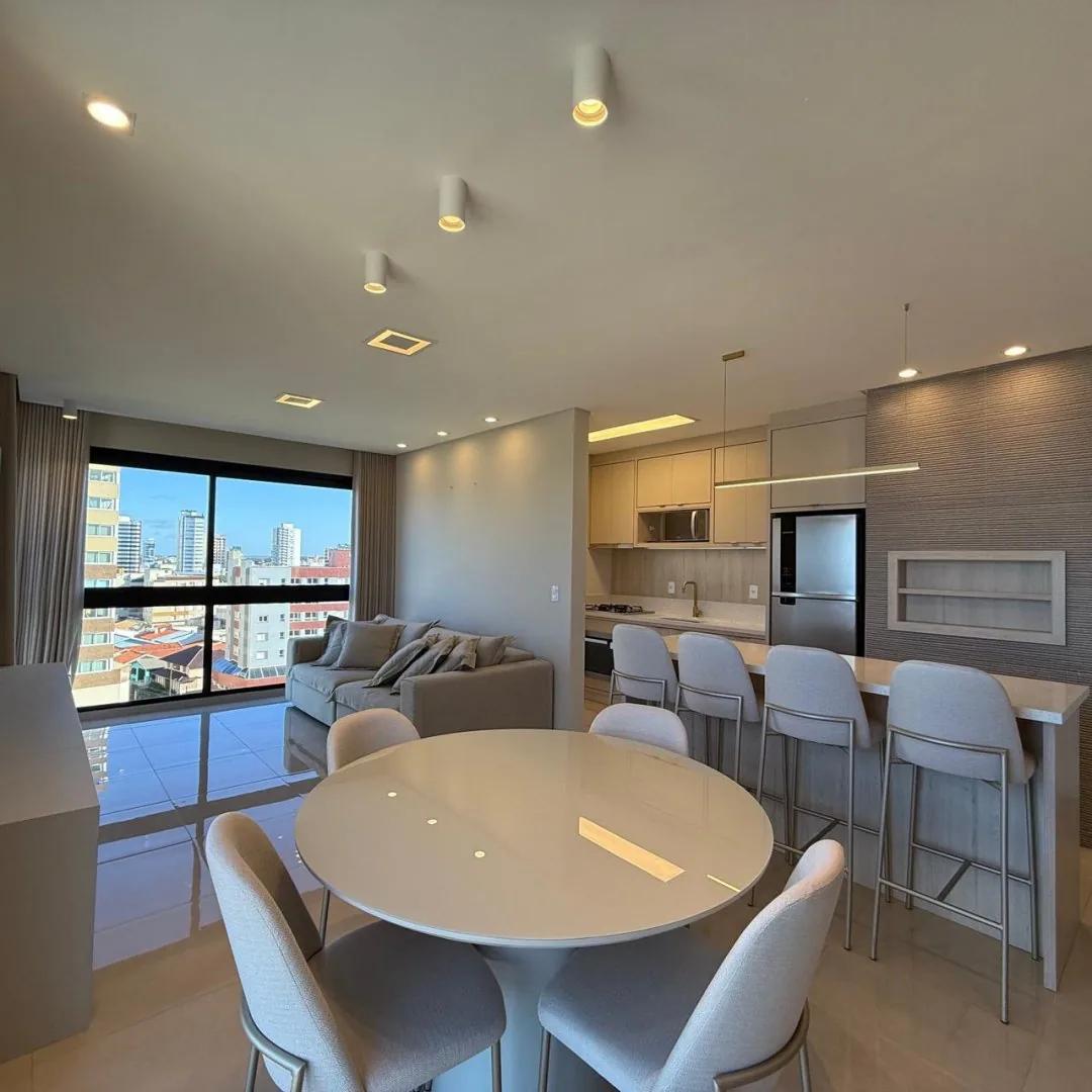 Estar com sofá claro e piso porcelanato.