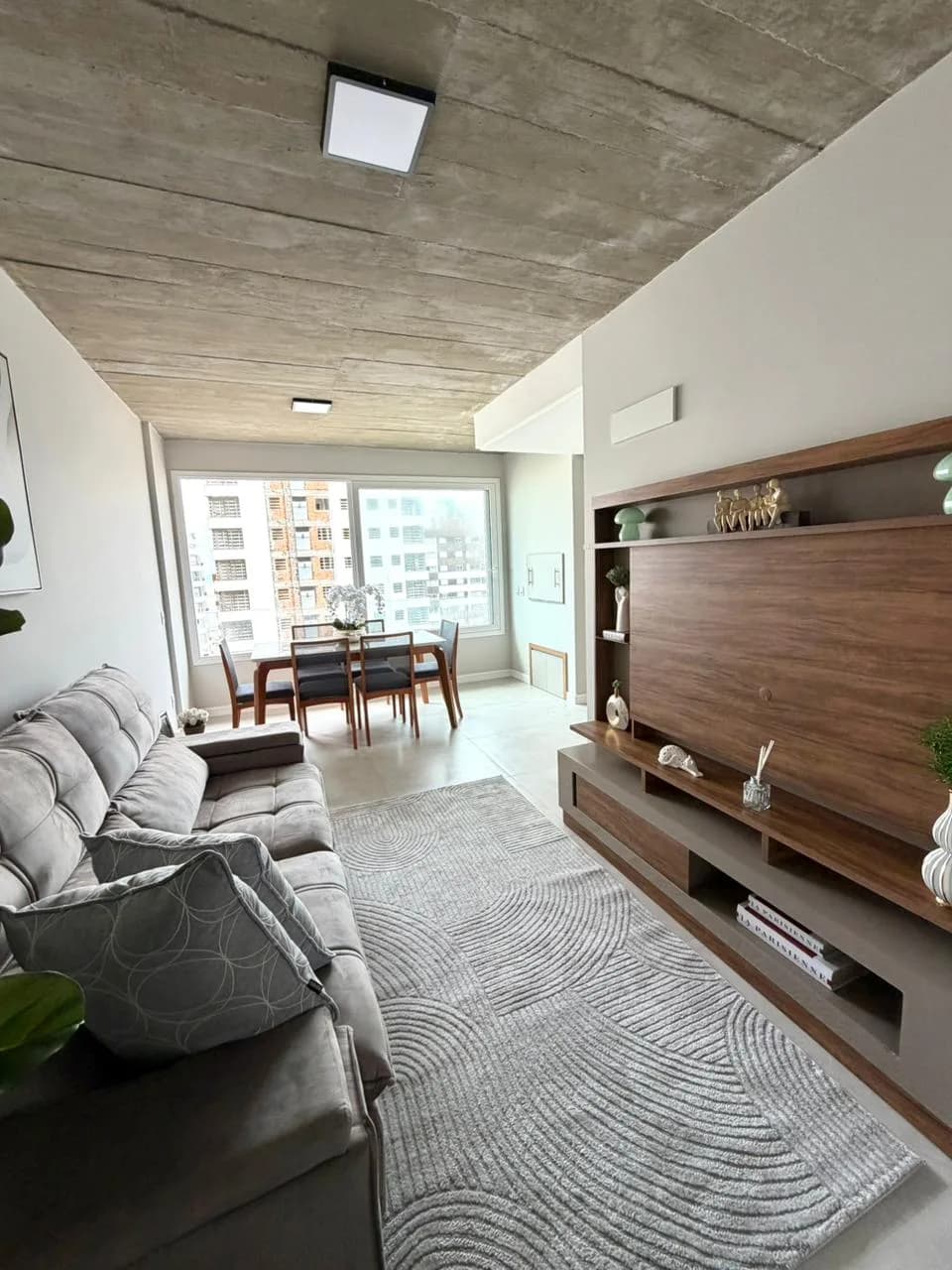 Sala de estar com rack de TV e poltrona