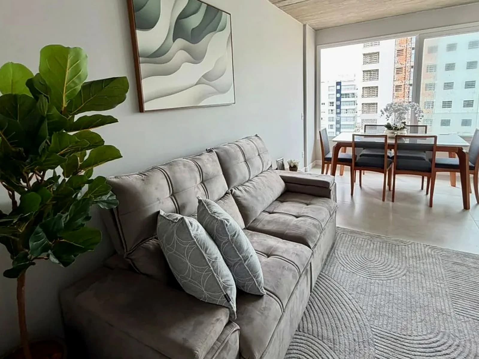 Sala de estar do apartamento na Zona Nova, com vista para o prédio ao lado.