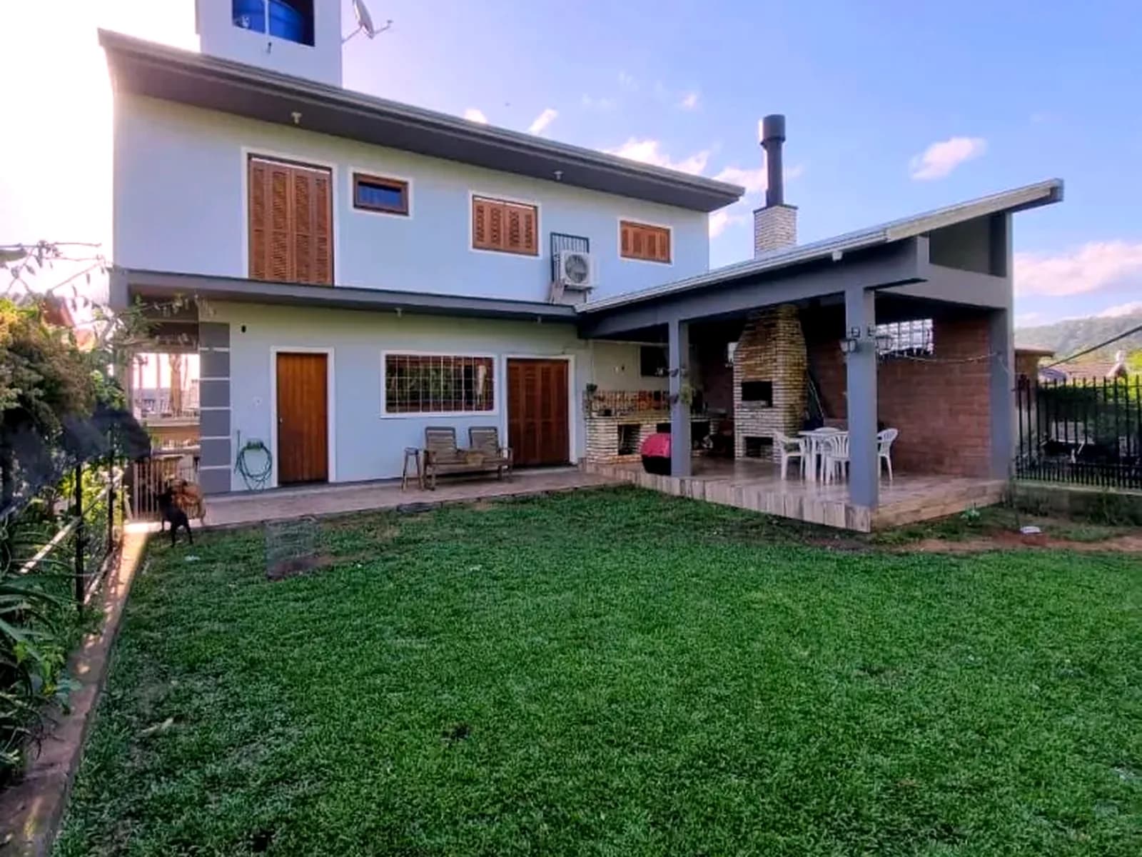 Os 120 m² de gramado nos fundos, com a casa ao fundo.
