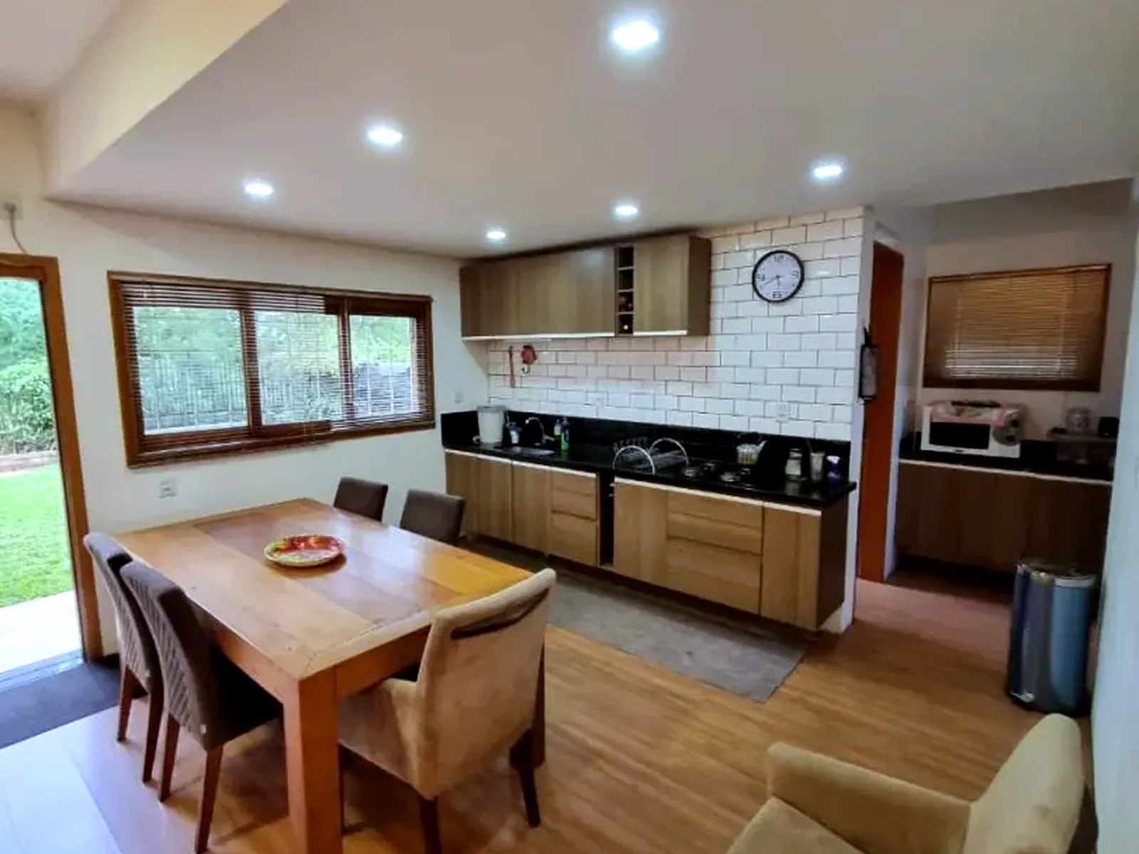 Cozinha e sala de jantar integradas, com janelas para o gramado.