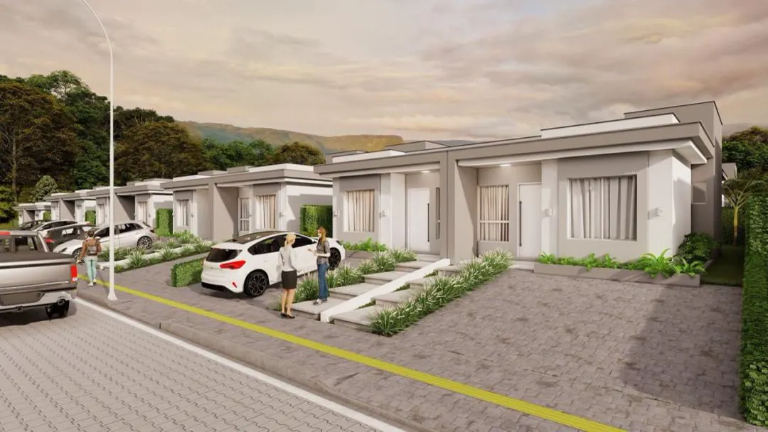 Rua interna do bairro Vale dos Plattanos ao entardecer, com fachadas de casas térreas em sequência.