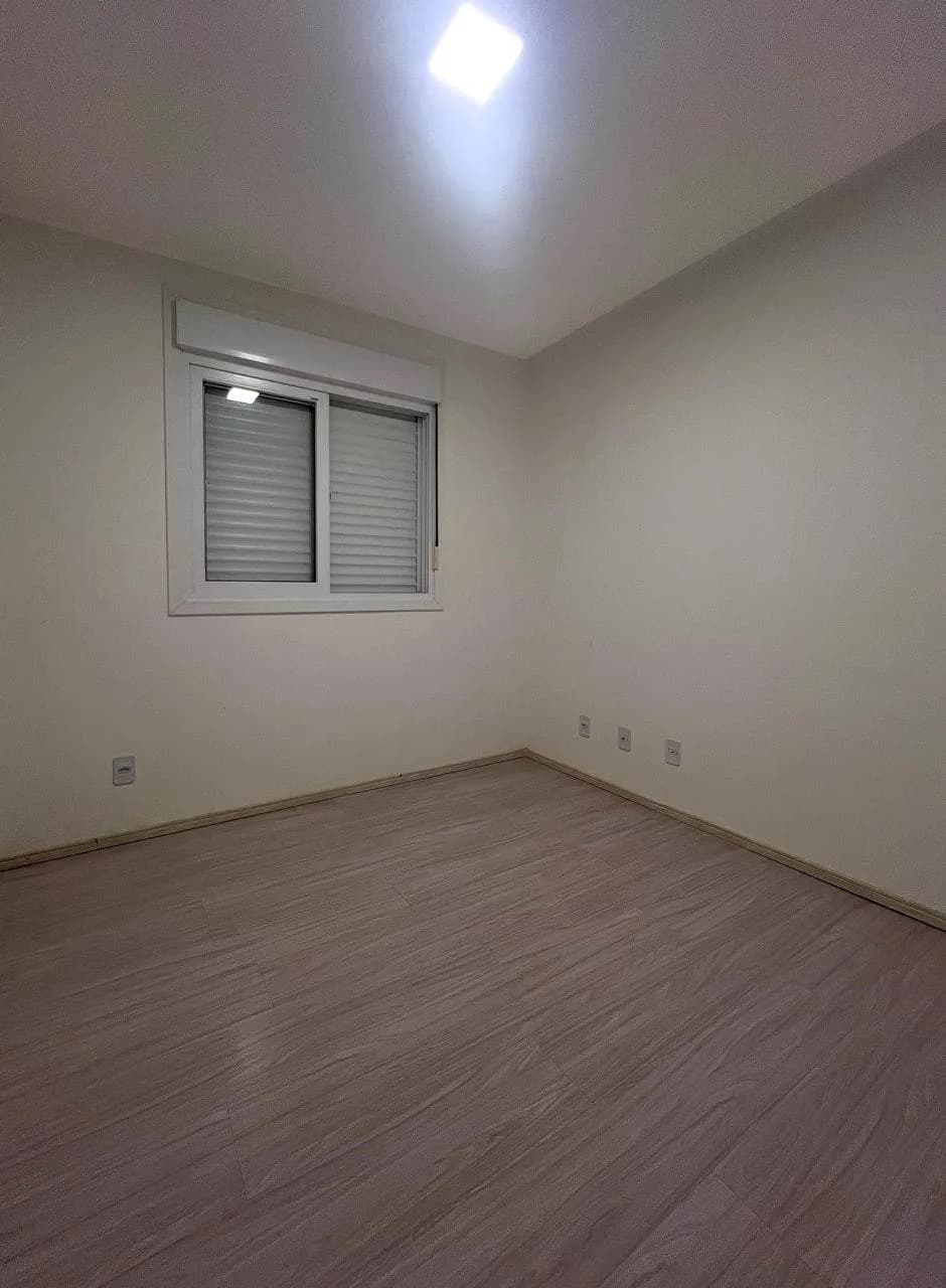 Segundo dormitório, com piso de madeira e janela para ventilação.