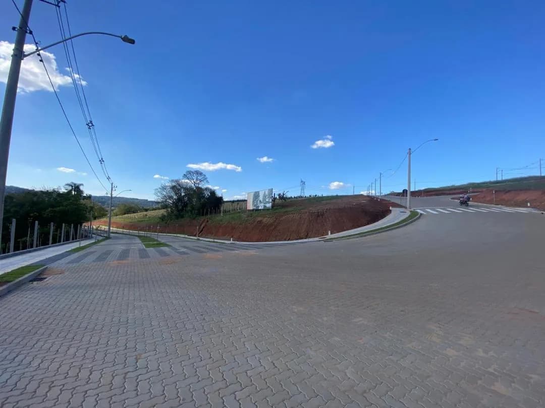 Rua do loteamento, pavimentada, com meio-fio e iluminação.