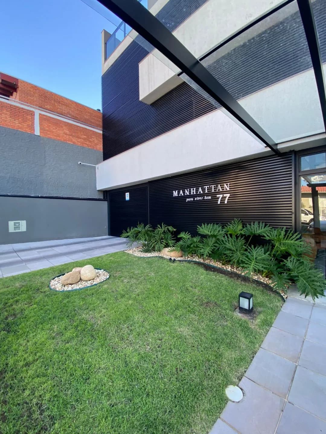 Fachada do Manhattan Residence, com jardim na frente.