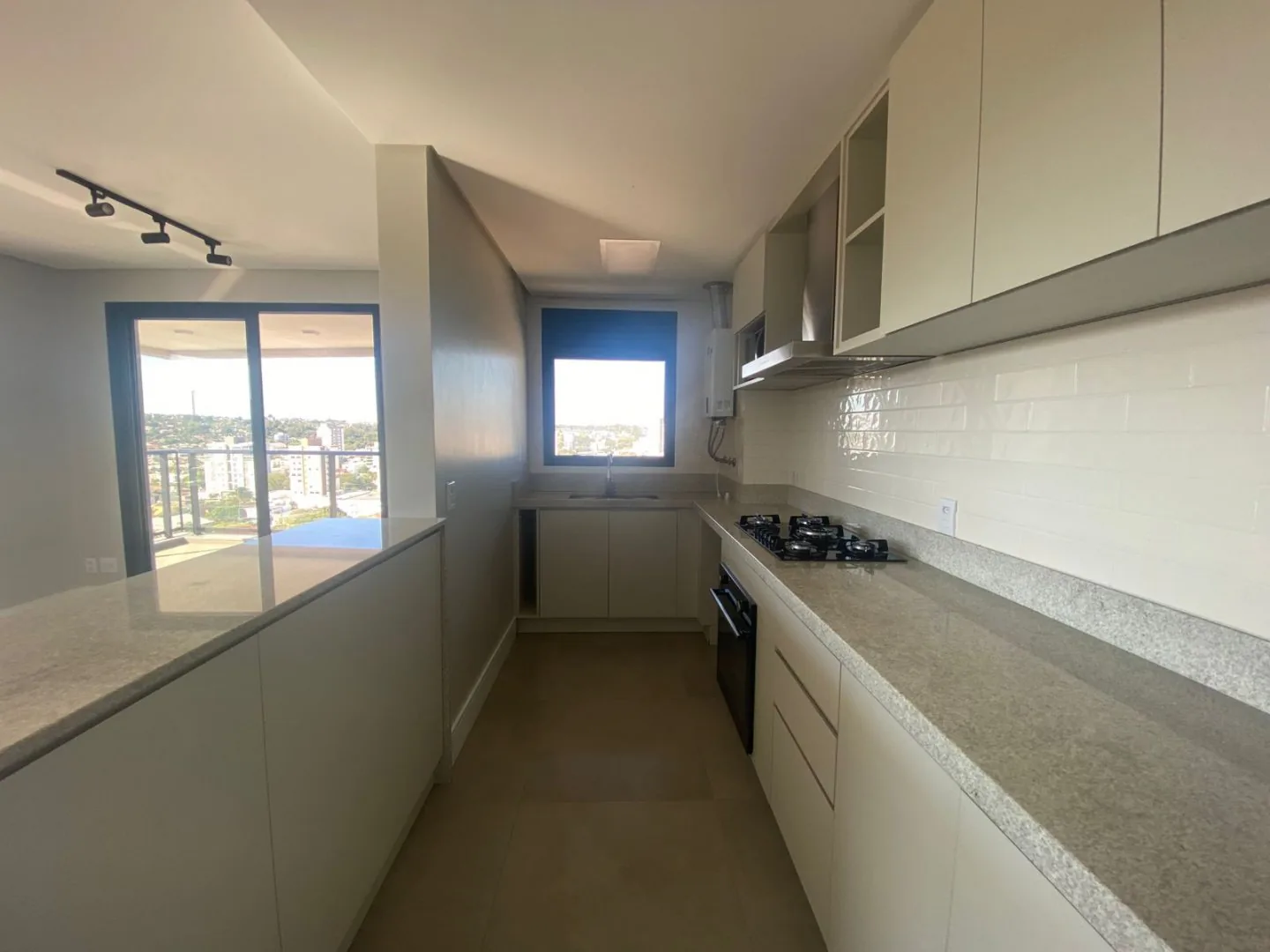 Cozinha com bancada de granito e cooktop.
