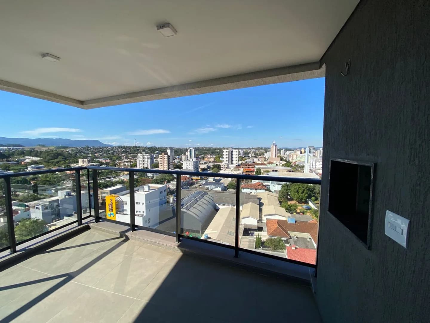 Sacada com churrasqueira e vista da cidade.