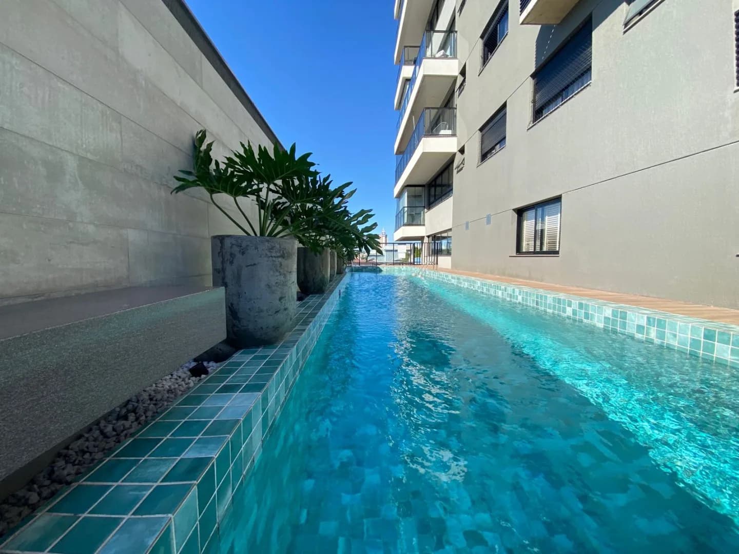 Piscina do condomínio, com revestimento azul.