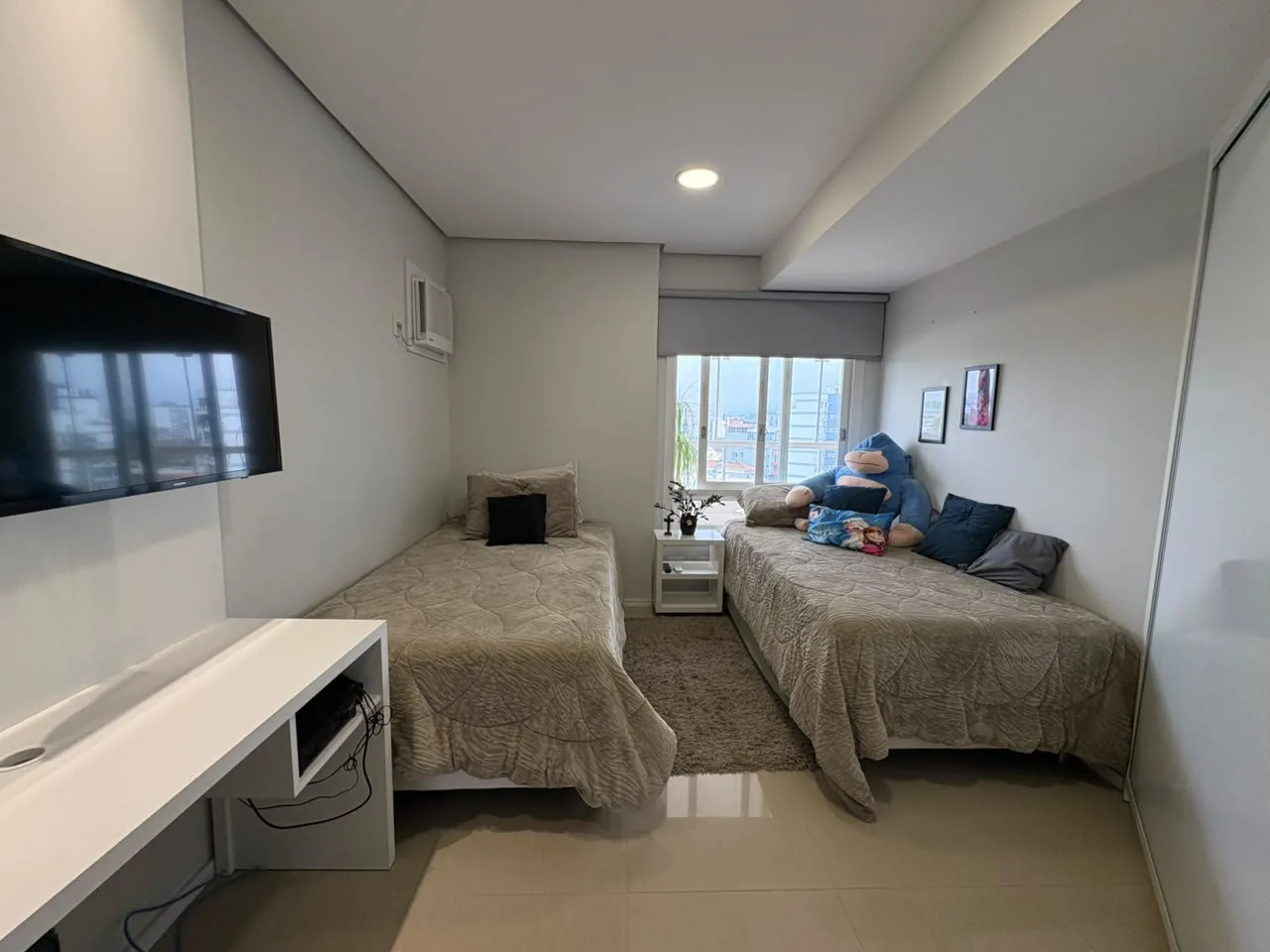 Dormitório com cama de casal e escrivaninha.