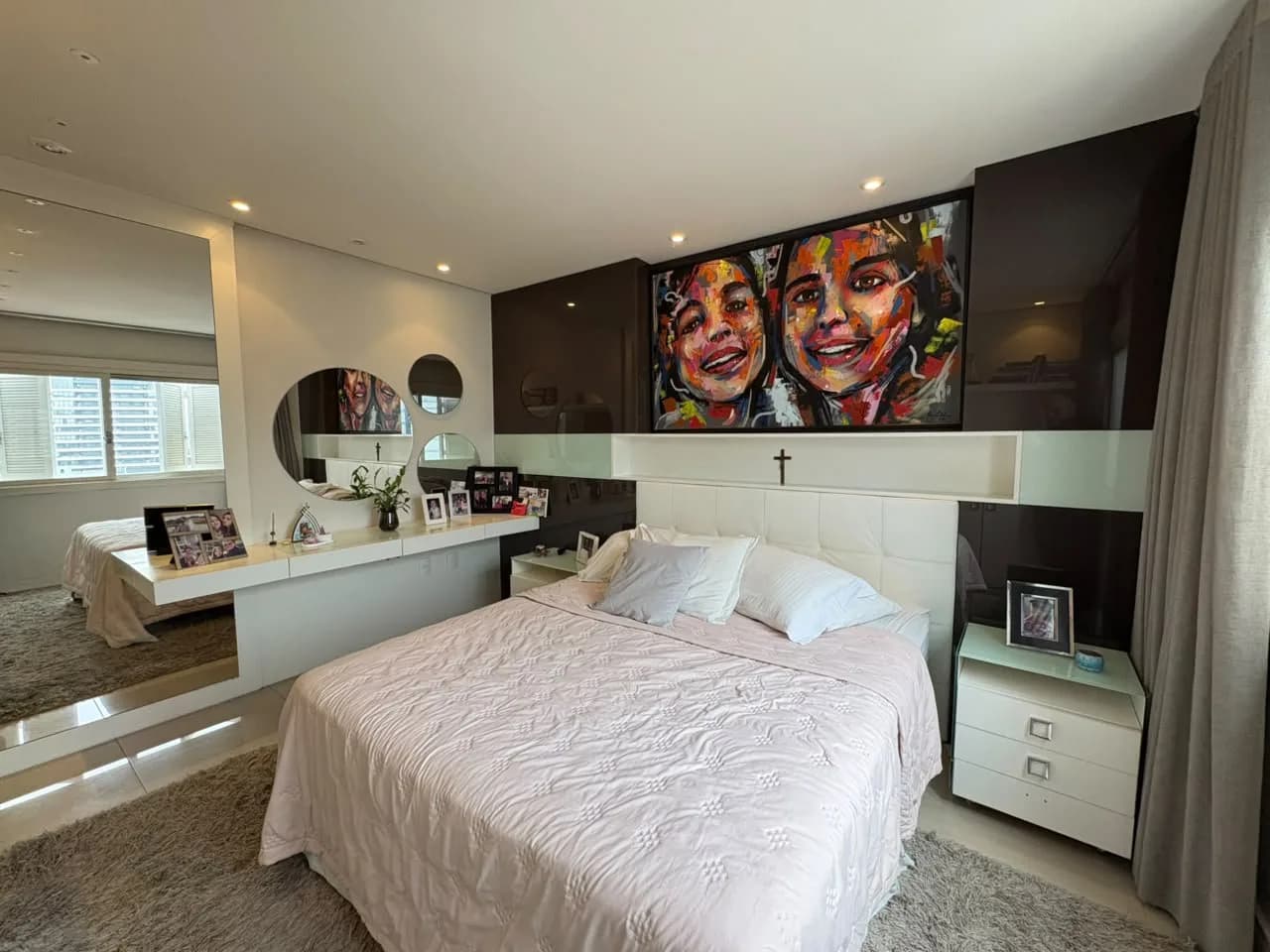 Suíte com cama de casal e cabeceira estofada.