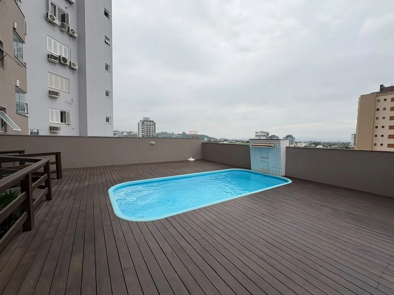 Piscina do condomínio, no deck de madeira.
