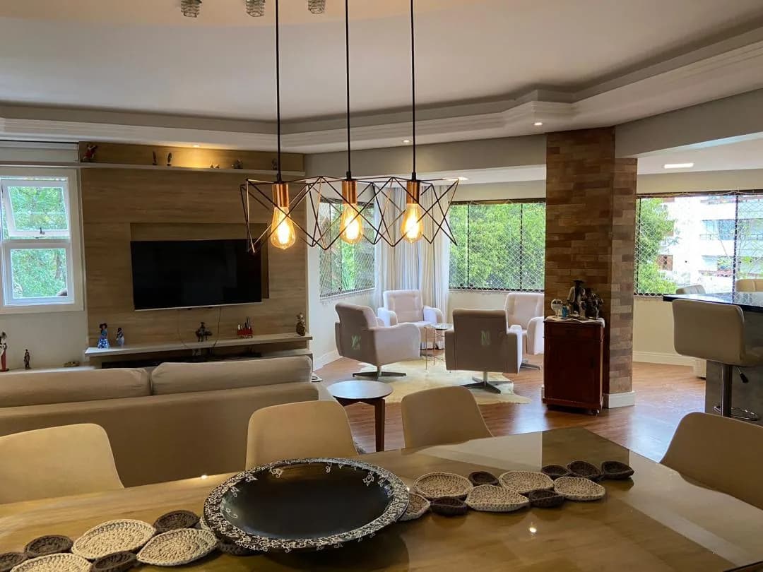 Sala de jantar com pendentes e mesa posta.