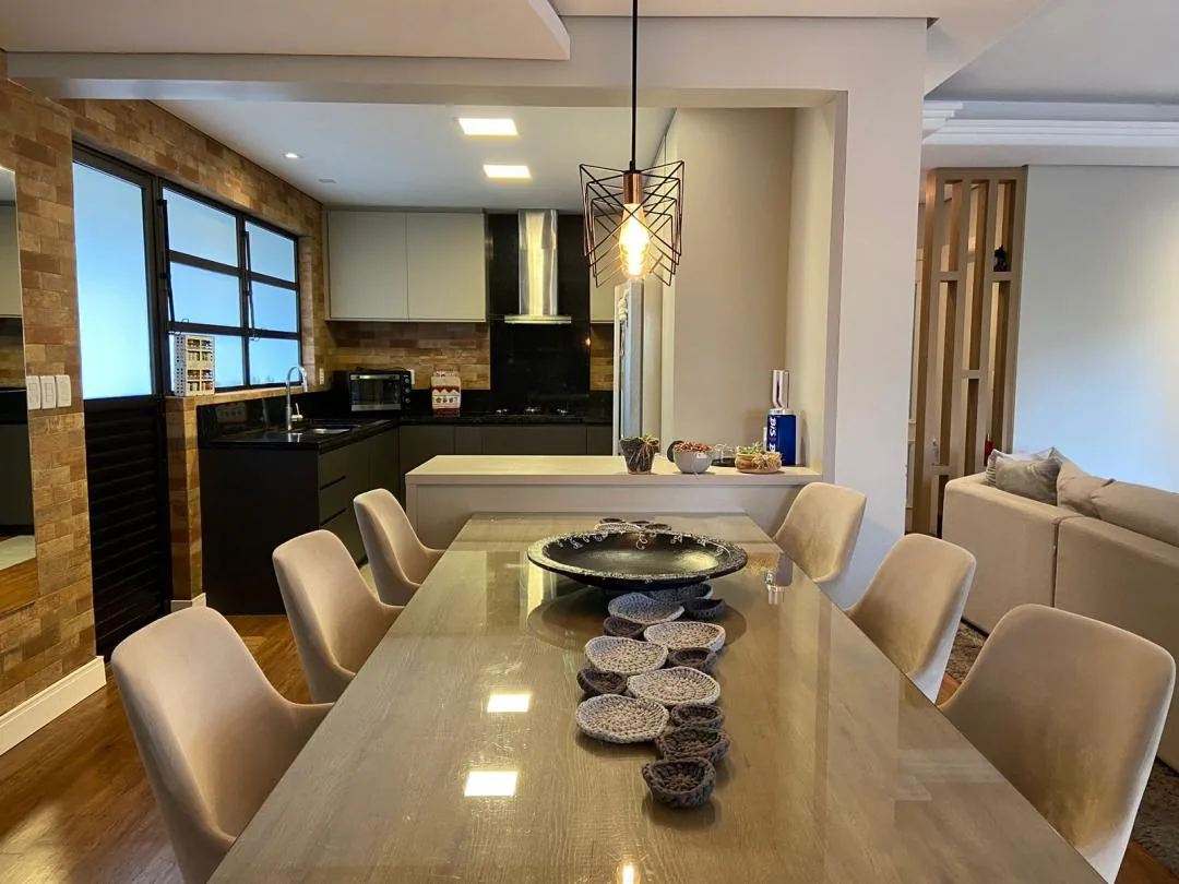 Espaço gourmet com bancada comprida e churrasqueira.