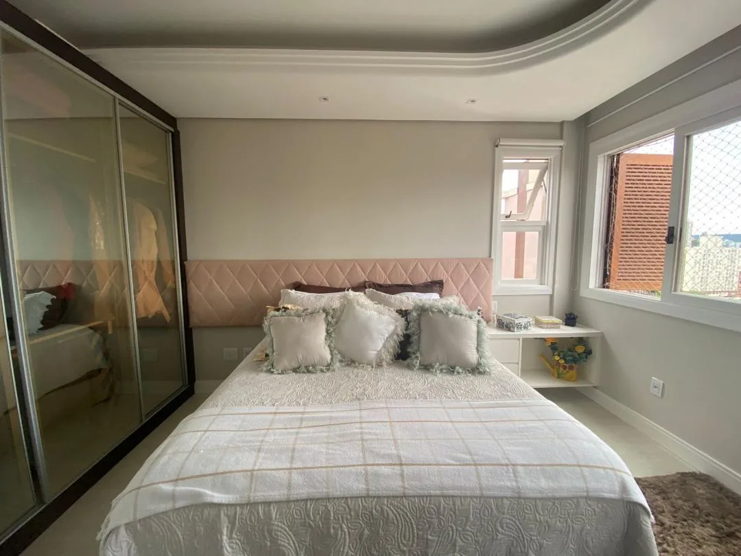 Dormitório com cama de casal e janela ampla.