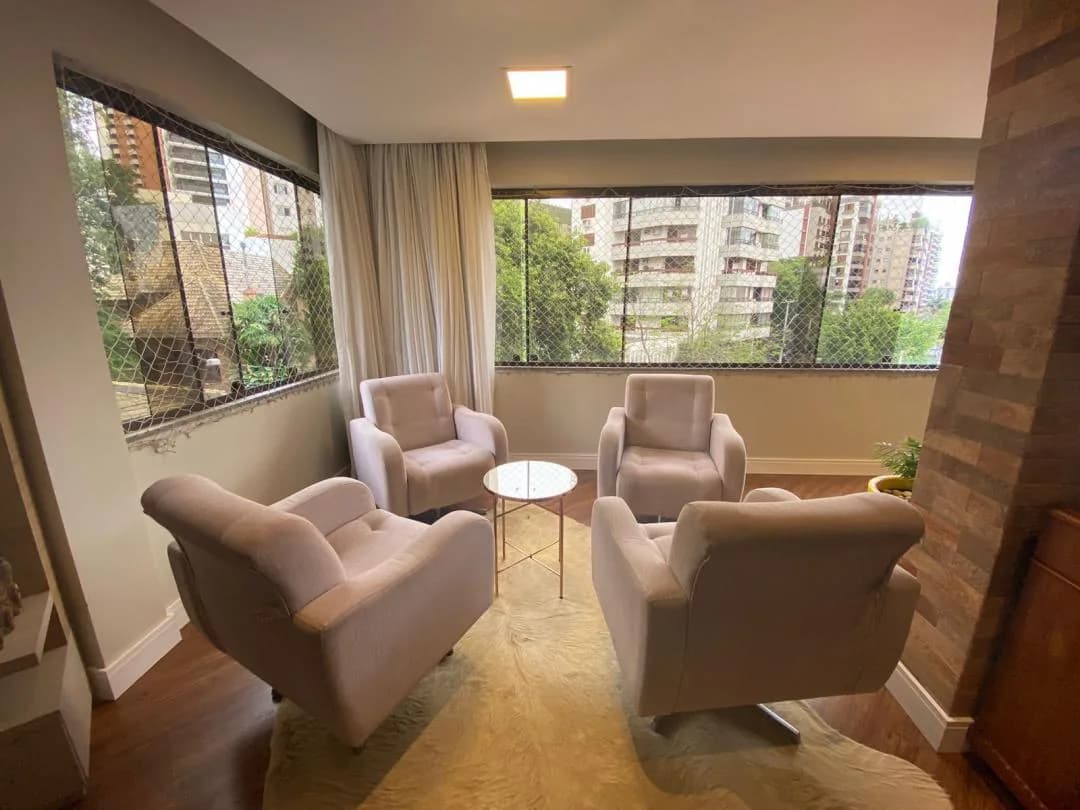 Sala de estar com poltronas junto à janela.