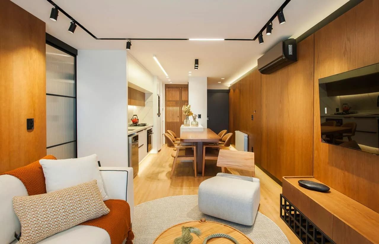 Sala de jantar junto ao estar, com cadeiras estofadas.