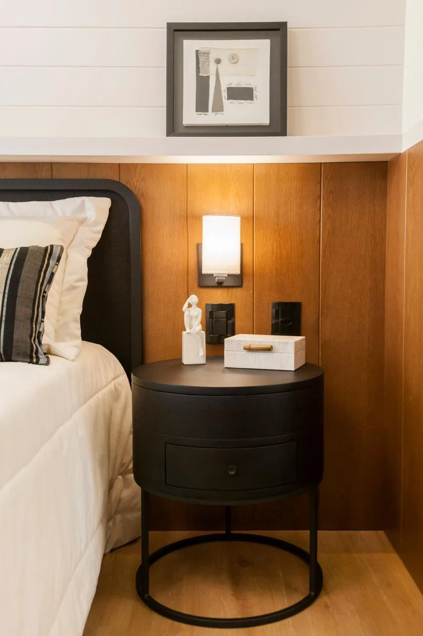 Suíte com cabeceira de madeira e roupa de cama xadrez.