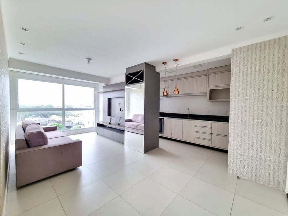 Sala de estar e jantar integradas, com cozinha ao fundo e janelas amplas