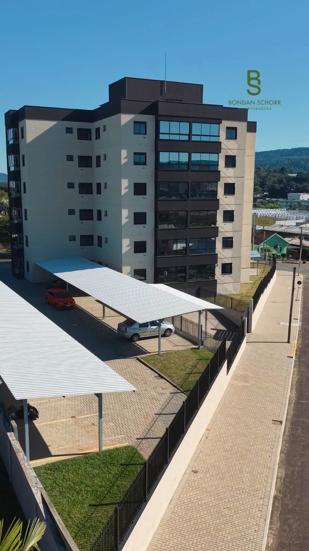 O Residencial Zurique visto de cima, com as garagens cobertas e o gramado do condomínio.