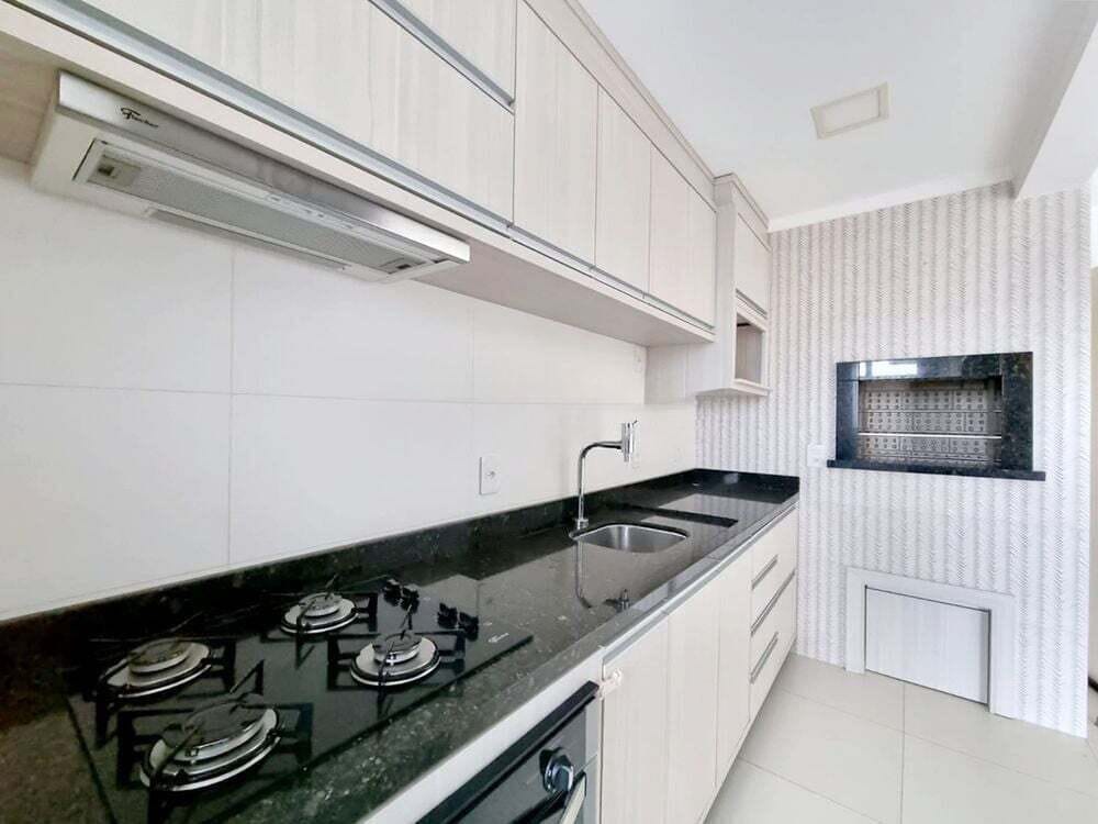 Cozinha com bancada em granito e fogão cooktop