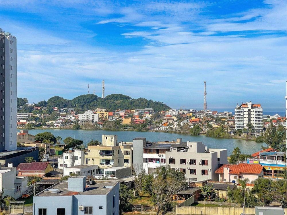 Vista aberta de uma janela, com lagoa e morro ao fundo