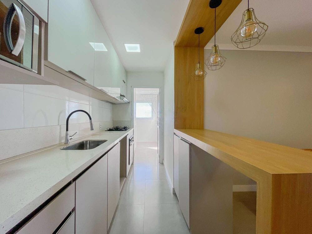 Cozinha em corredor, com bancada de quartzo