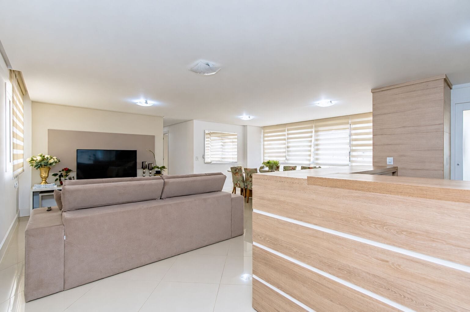 Sala de estar com sofá e TV, vista ampla