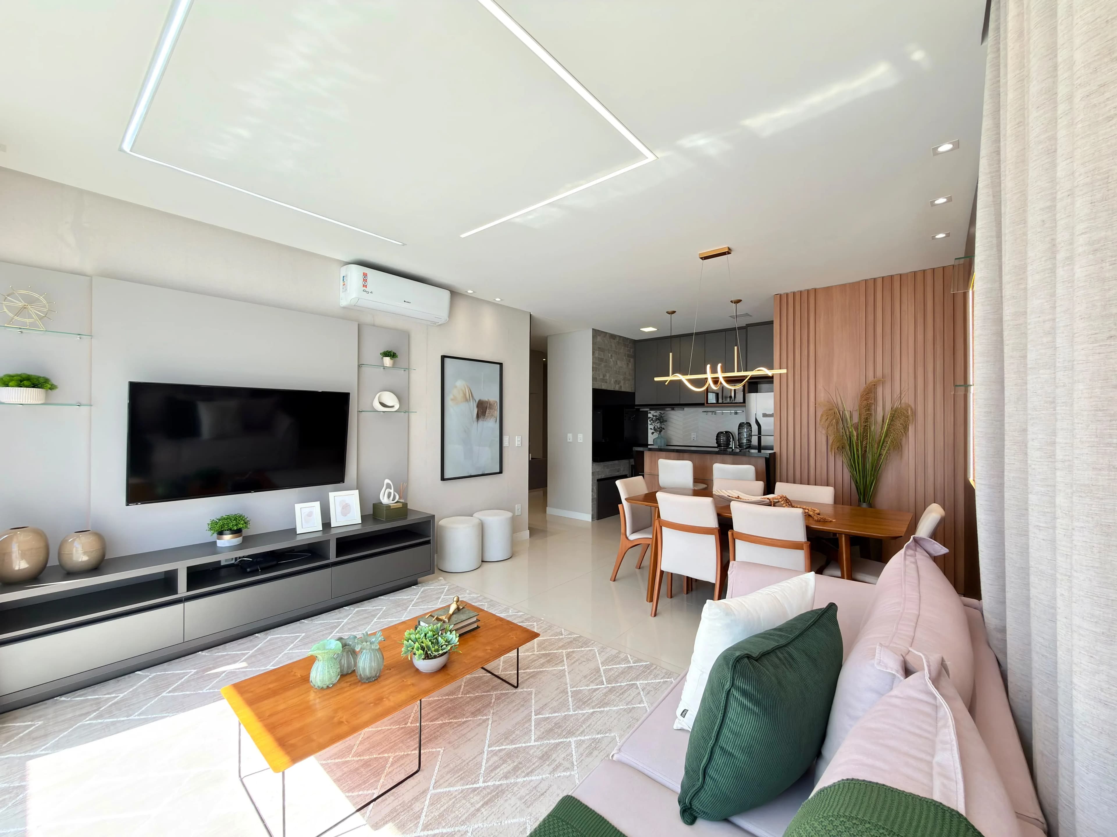 Sala de estar e jantar integradas, com painel de madeira e vista para os prédios vizinhos