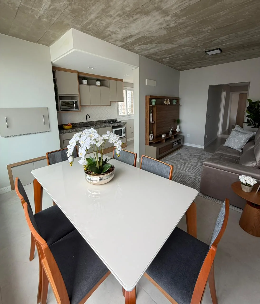 Sala de estar e jantar integradas, com mesa para quatro lugares