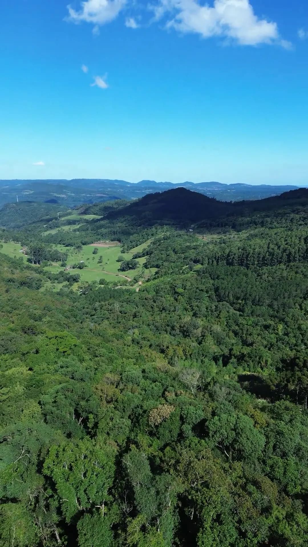 Vista ampla do vale, da mata e do céu aberto sobre a serra.