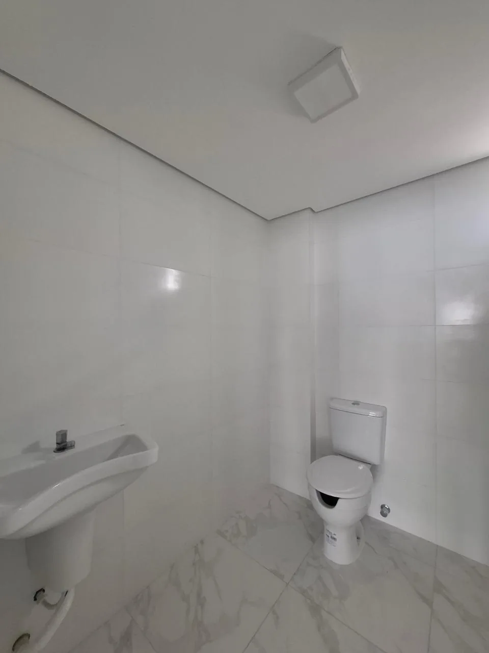 Segundo banheiro do pavilhão, com vaso sanitário e revestimento em pedra