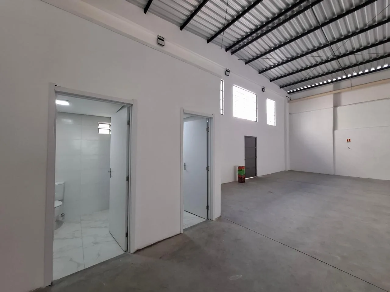 Corredor interno com portas abertas para os dois banheiros
