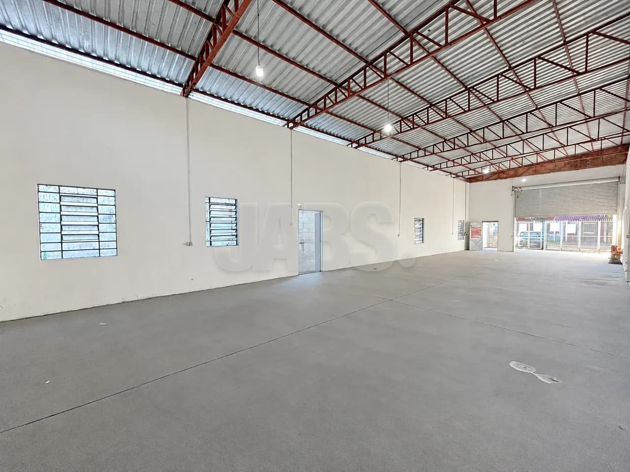Interior do pavilhão com piso de concreto