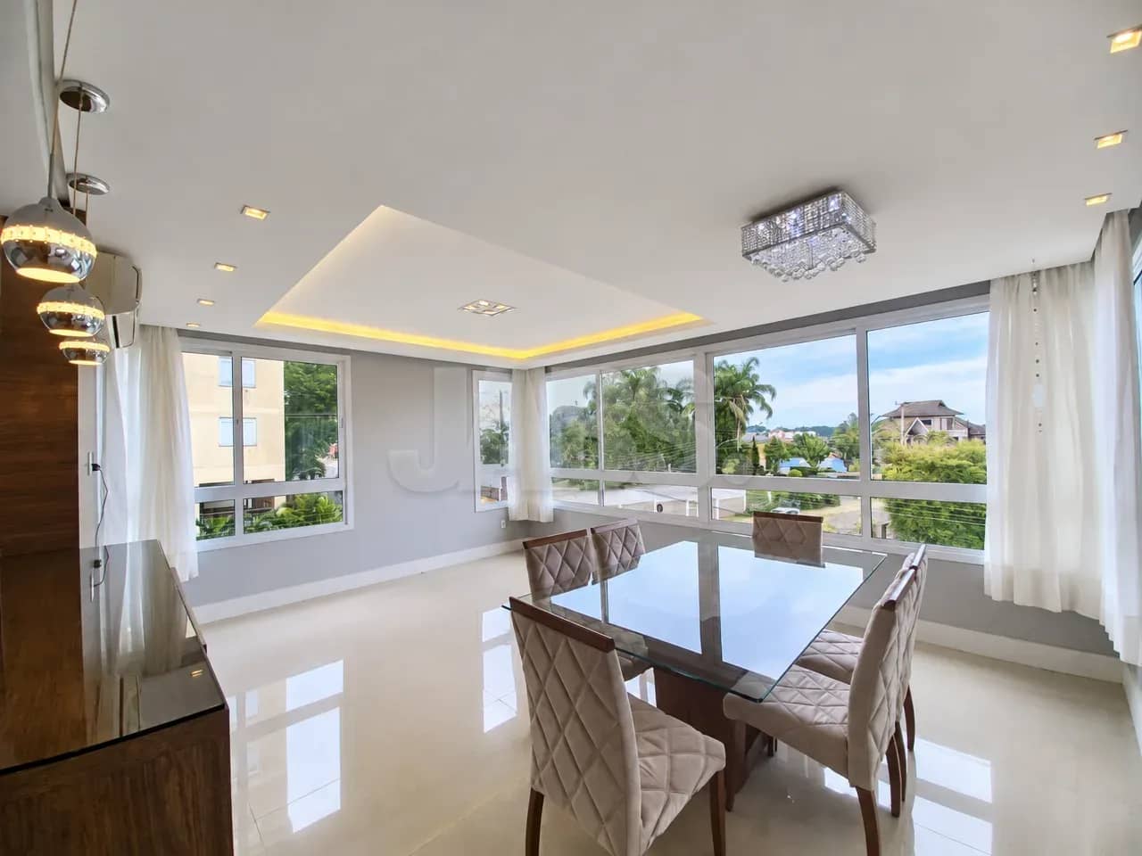Living com mesa de jantar e janelas amplas
