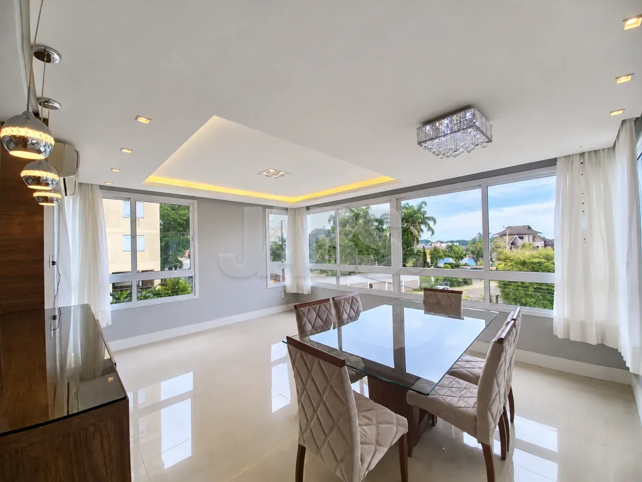 Living com mesa de jantar e janelas amplas
