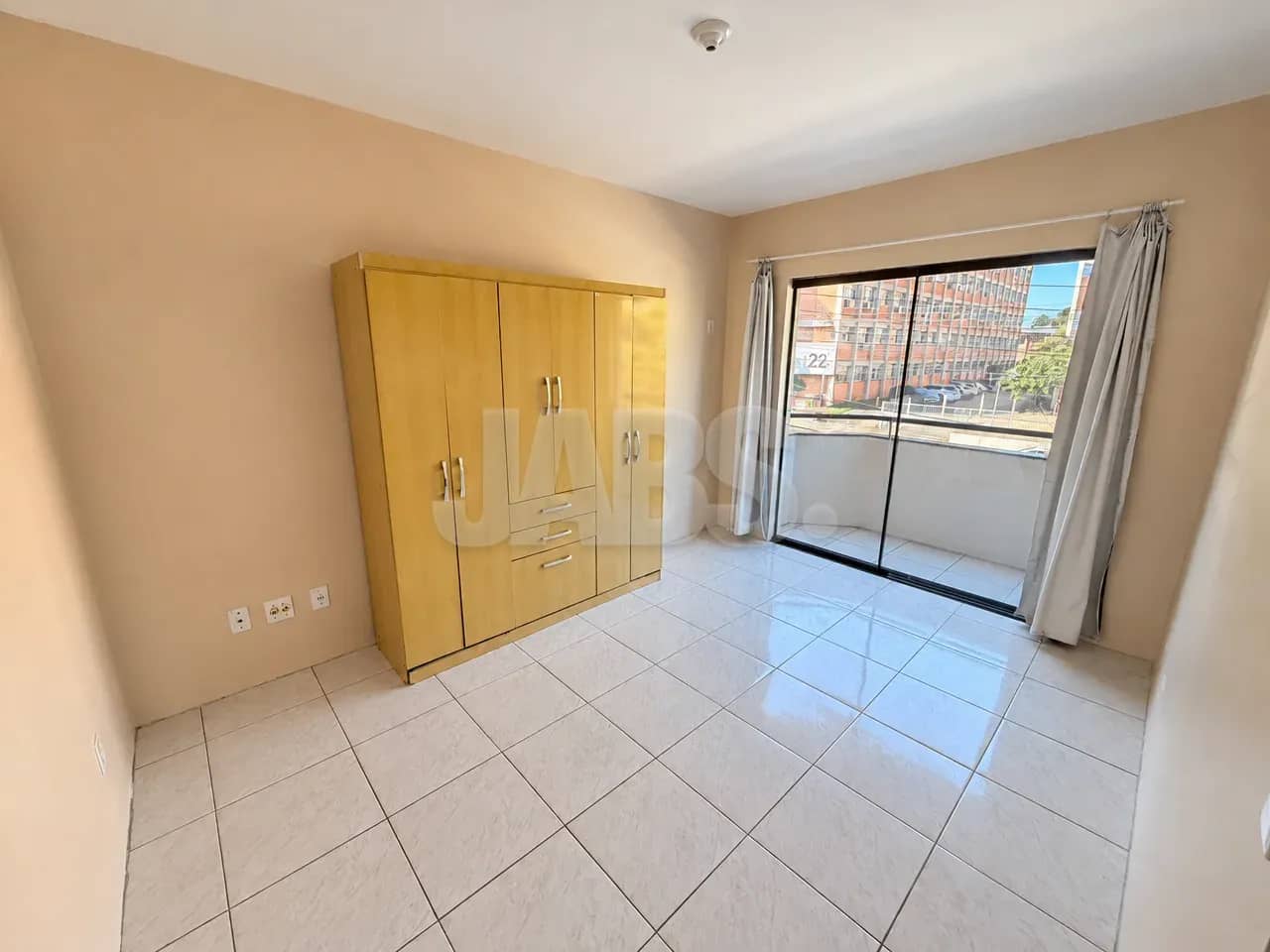 Quarto com guarda-roupa e sacada