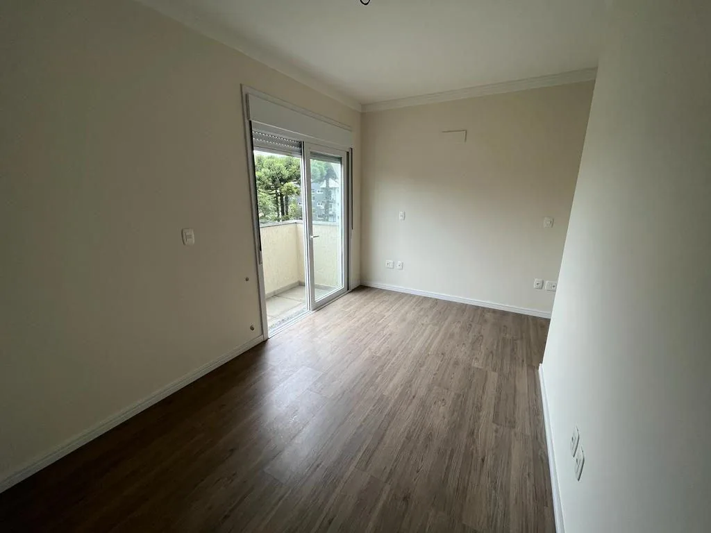 Quarto com piso laminado, moldura de gesso no teto e porta de vidro com persiana para a sacada