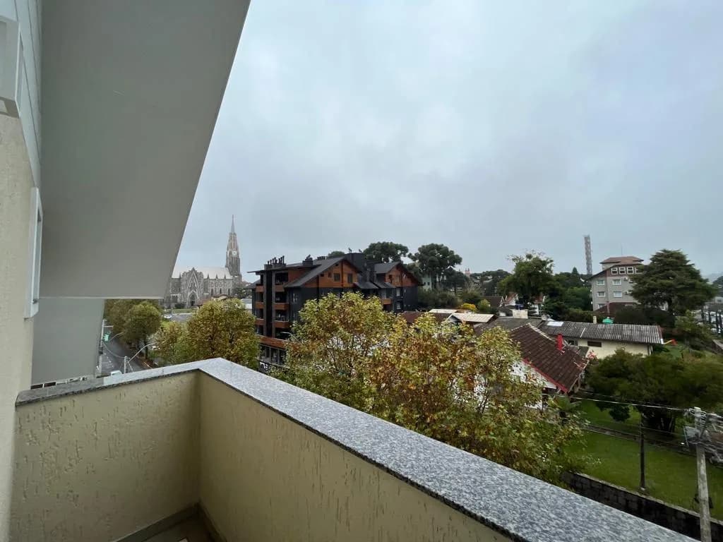Sacada com vista para os telhados do centro de Canela e a torre da Catedral de Pedra ao fundo